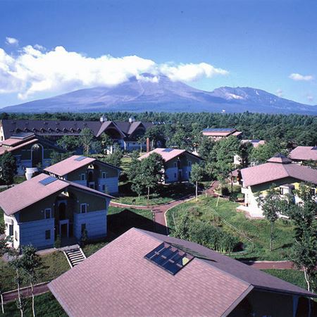 紀州鉄道　軽井沢ホテル列車村コテージ。画像奥にホテル本館、さらに雄大な浅間山を望む